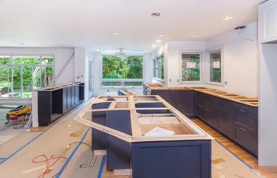 Countertop template laid over new navy island cabinets during a kitchen remodel
