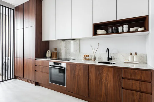 Modern kitchen with walnut tall cabinets, white uppers and marble backsplash